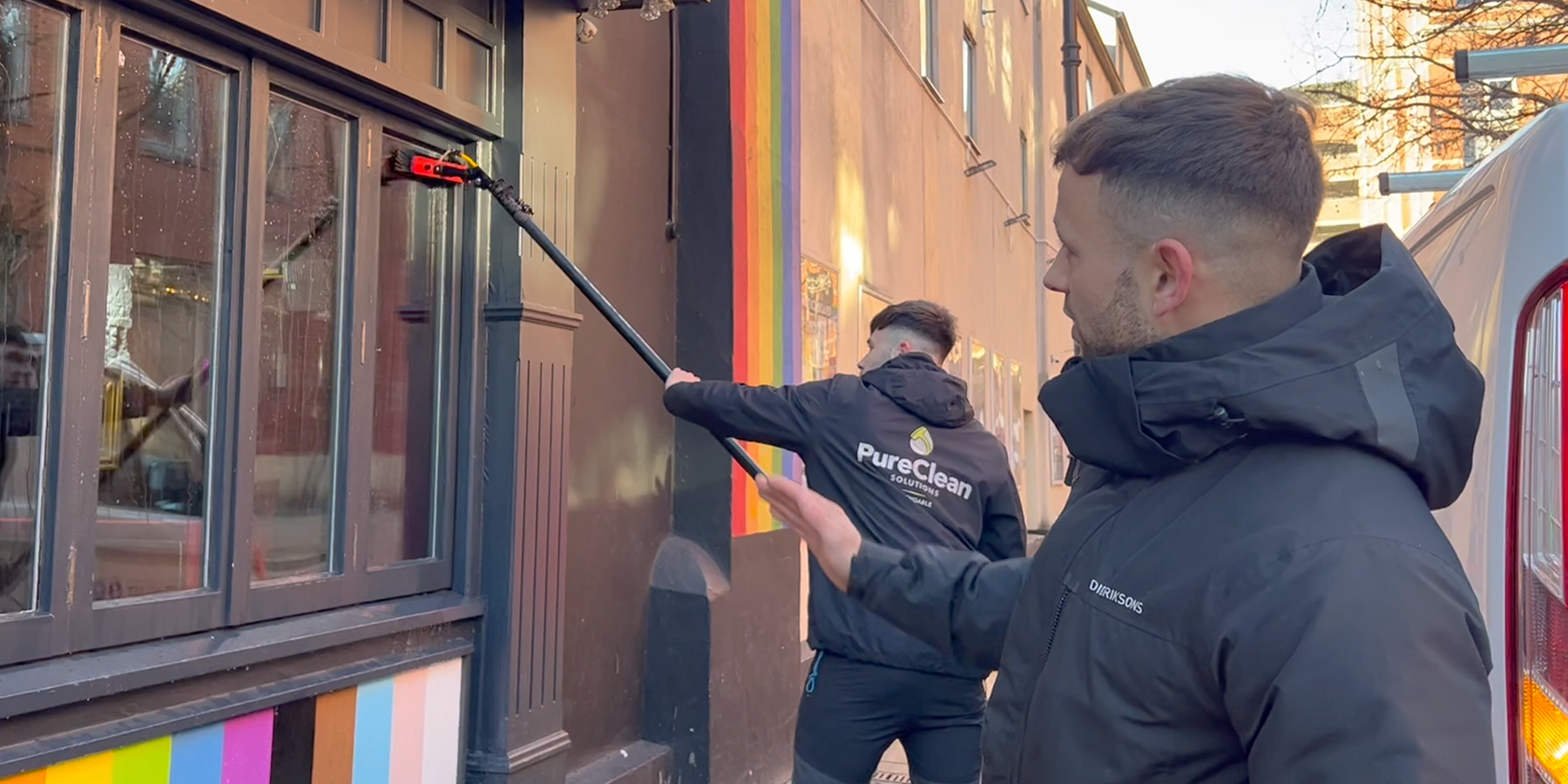 Two Pureclean employees cleaning windows